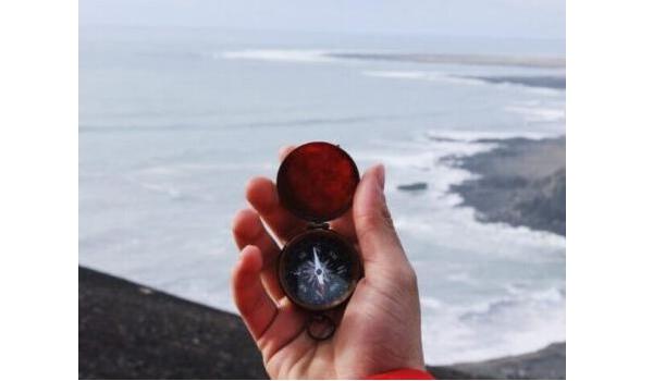 Compass held in front of a sea