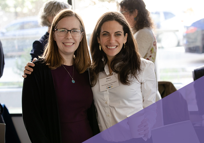 two young professionals pose together and smile for the camera at CASJE event