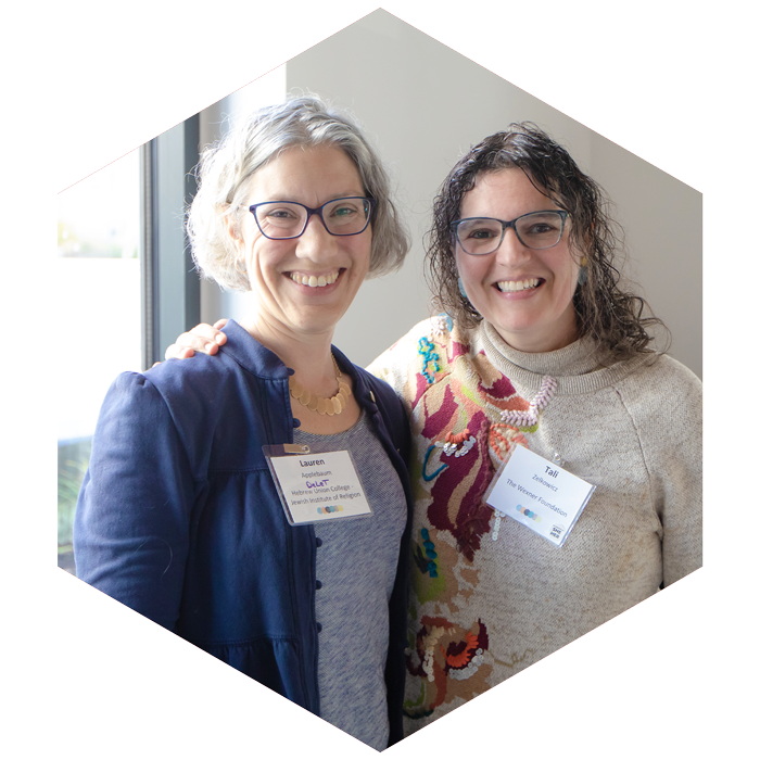 Lauren Applebaum and Tali Zelkowicz pose together and smile at camera at CASJE event (image is hexagon shaped)