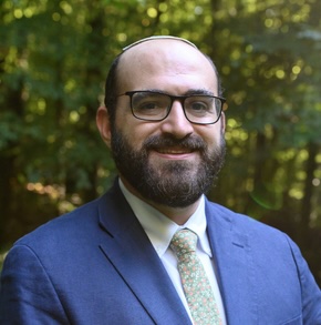 Man in blue suit with grey tie and glasses