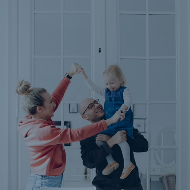 Family holding child in the air, blue background overlay