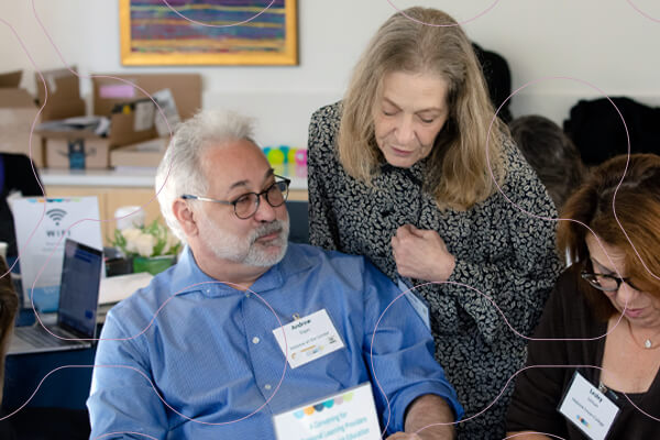 three professionals look at document on table at CASJE event
