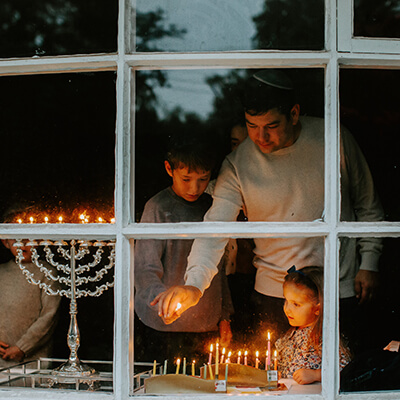 family and menorah through window