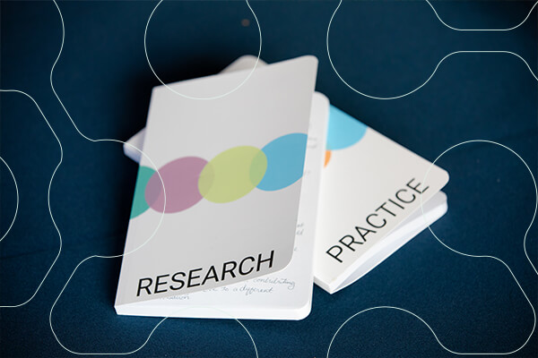 Two notebooks, one says "Research", the other "Practice"