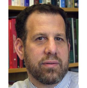 Man with beard in front of bookshelf
