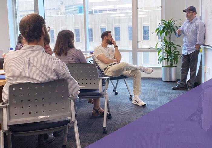 Fellowship mentor stands and speaks to small group of research fellows
